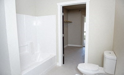 a white bathroom with a toilet and a shower
