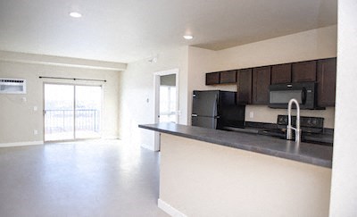 an empty kitchen with a counter and a refrigerator