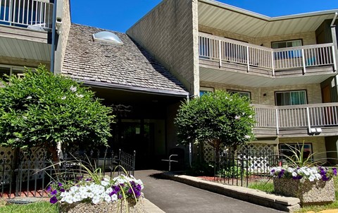 A building with a balcony and a small garden in front.