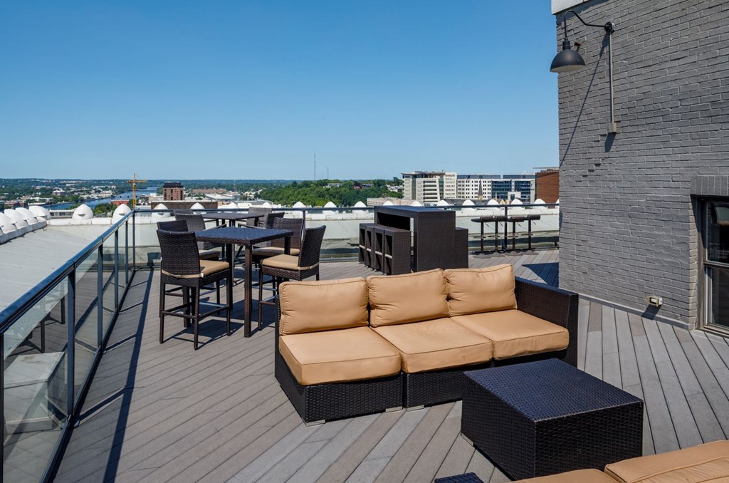 a rooftop patio with a couch and tables