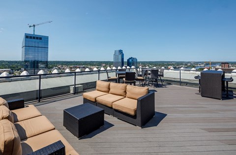 a rooftop terrace with couches and tables on a roof