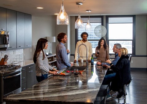 a group of people standing around a kitchen counter