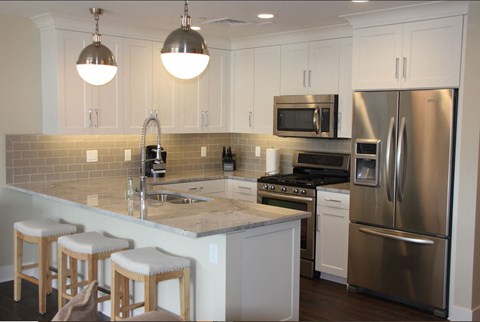 a kitchen with stainless steel appliances and white cabinets