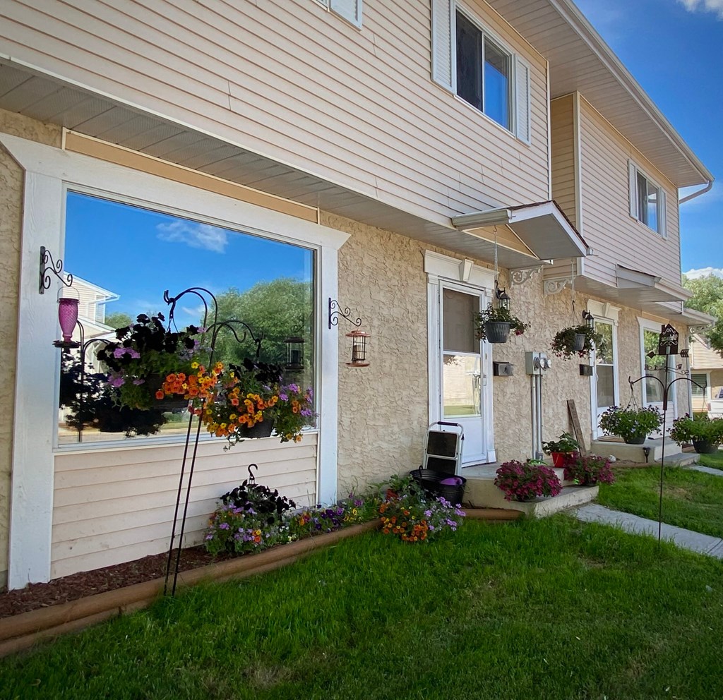 a house with a lawn and flowers in front of it