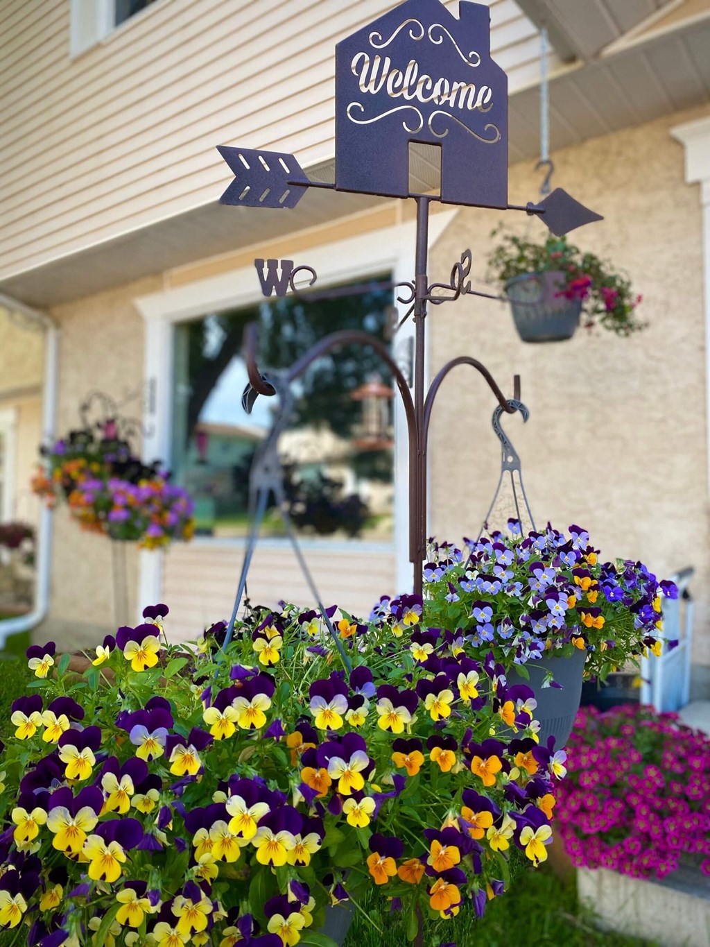 a flower pot with a welcome sign in front of a building