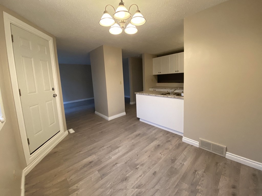 a renovated living room and kitchen with wood flooring