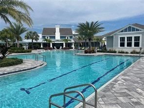 a large swimming pool with a house in the background