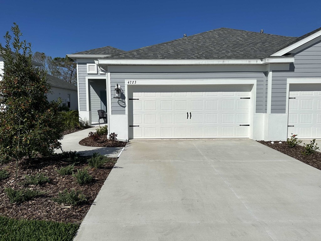 a white house with a driveway and a white garage door
