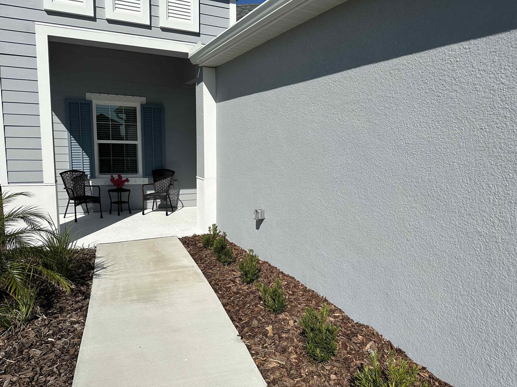 a walkway leading to a house with a patio