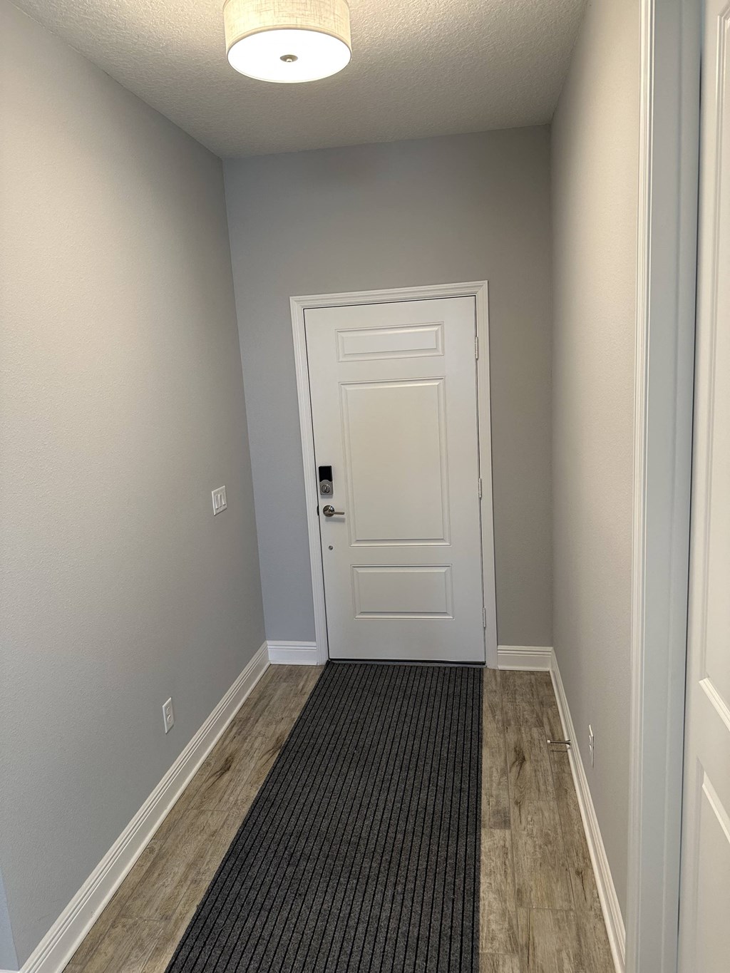 an empty hallway with a white door and a carpeted floor