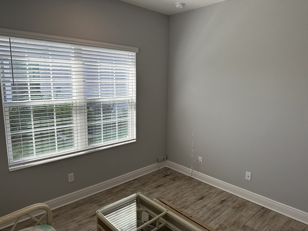 an empty room with a large window and a wooden floor