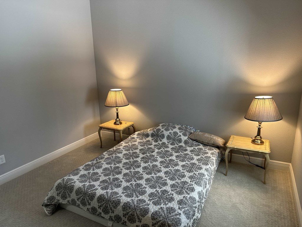 a bedroom with a bed and two lamps