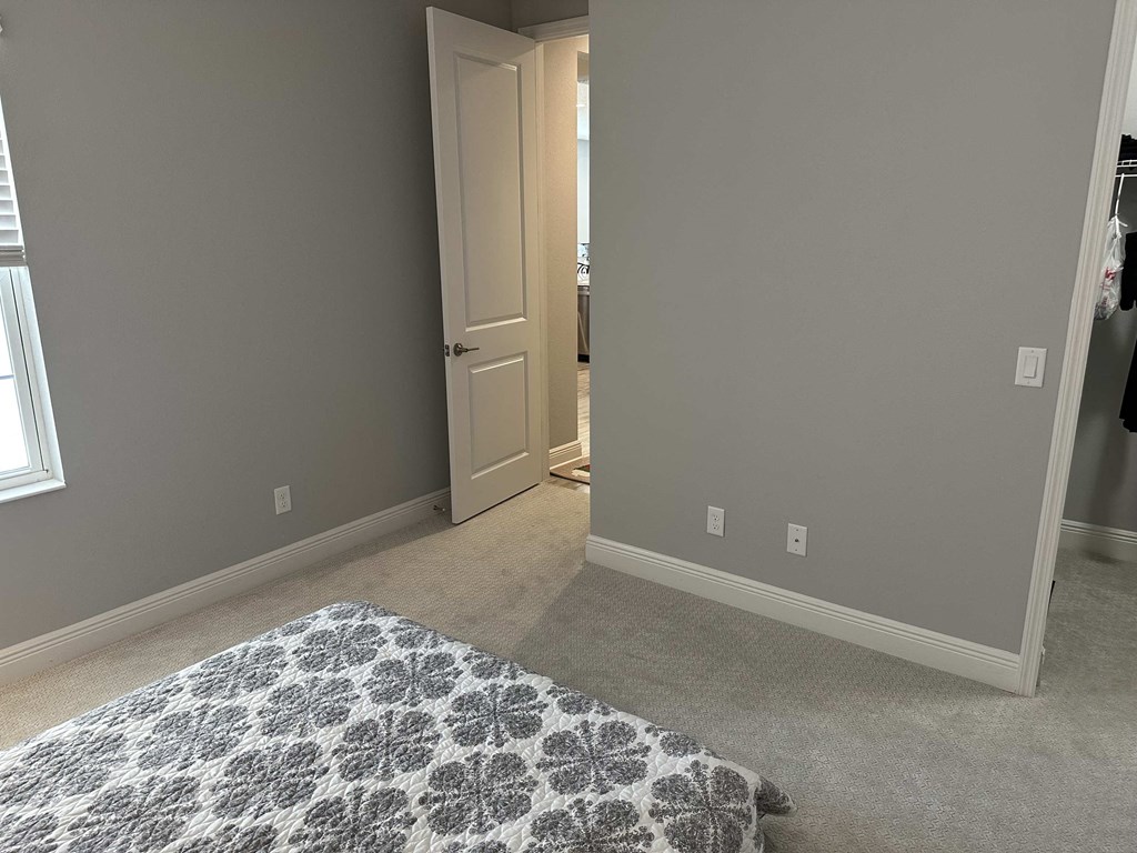 a bedroom with a bed and a doorway to a closet