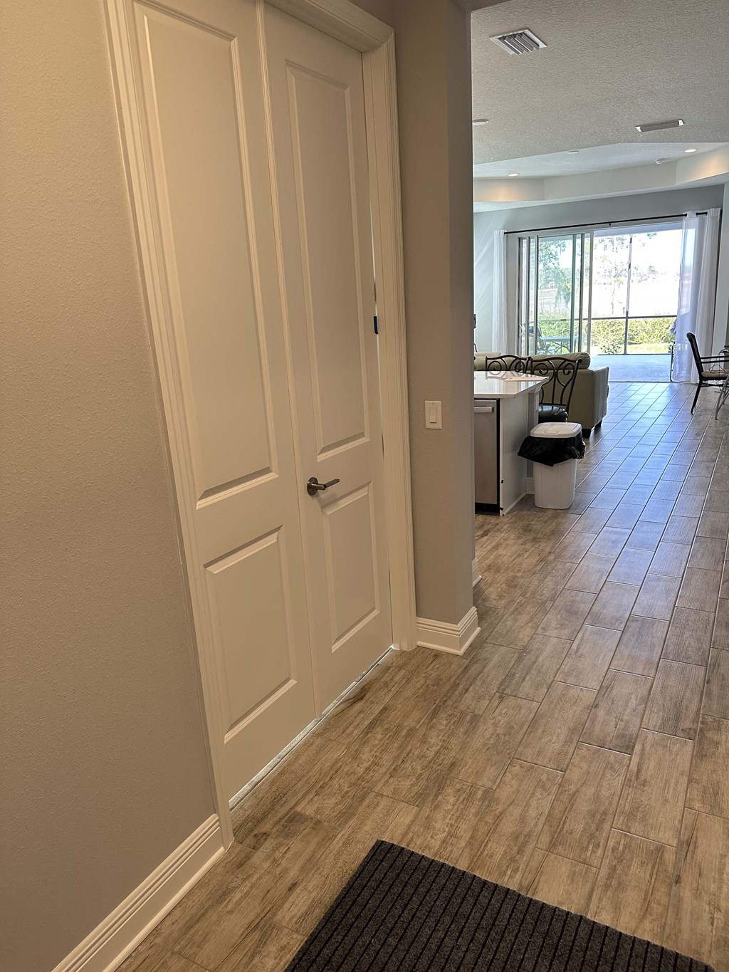a hallway with two doors and a dining room with a table and chairs