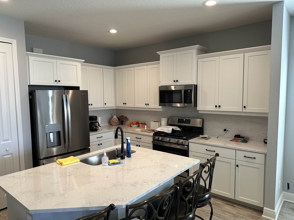 a kitchen with white cabinets and stainless steel appliances