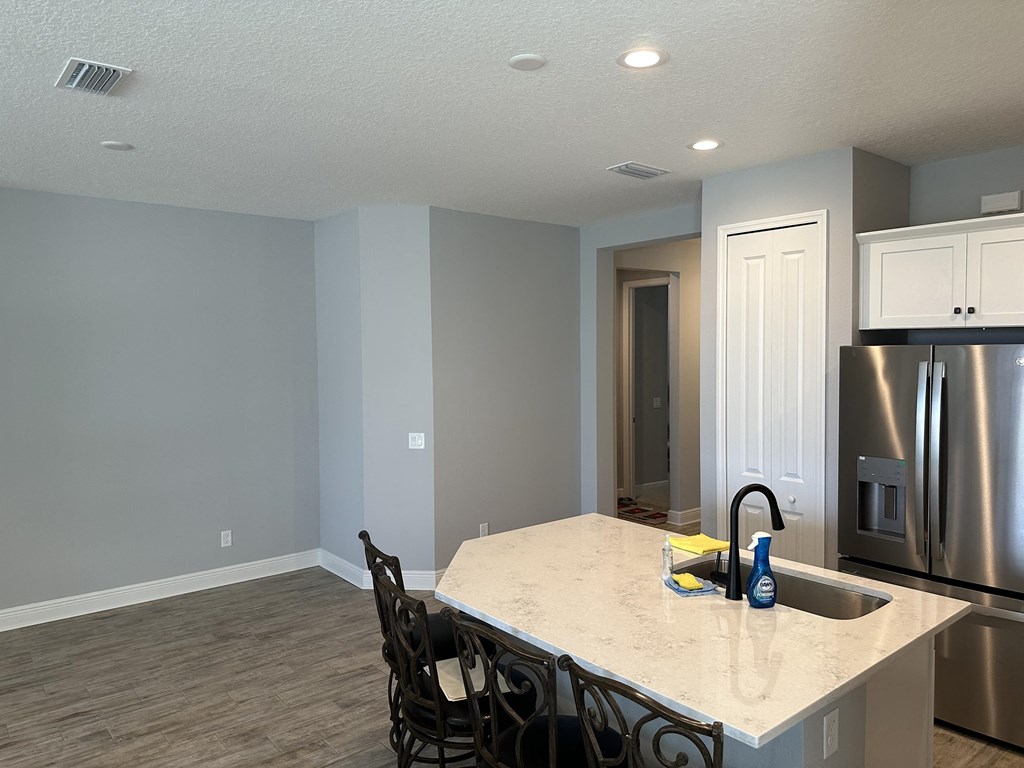 a kitchen with a large island and a stainless steel refrigerator