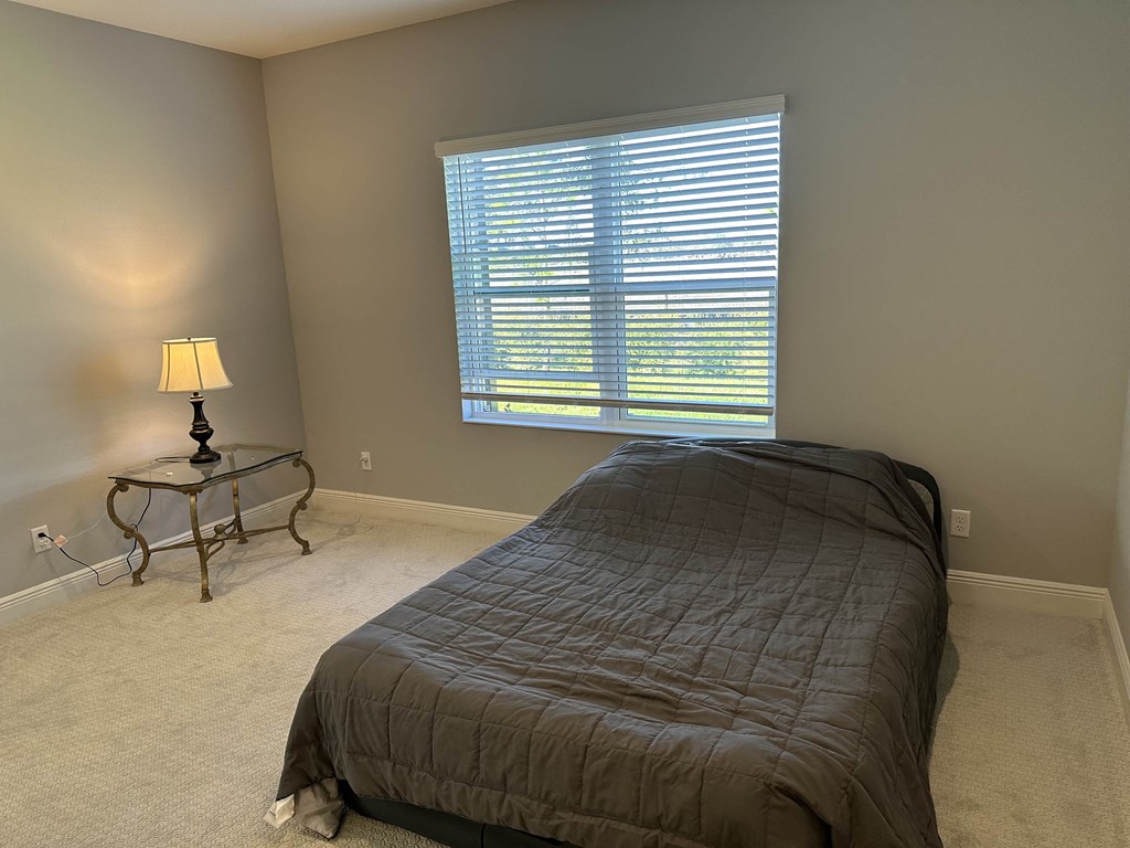 a bedroom with a bed and a window