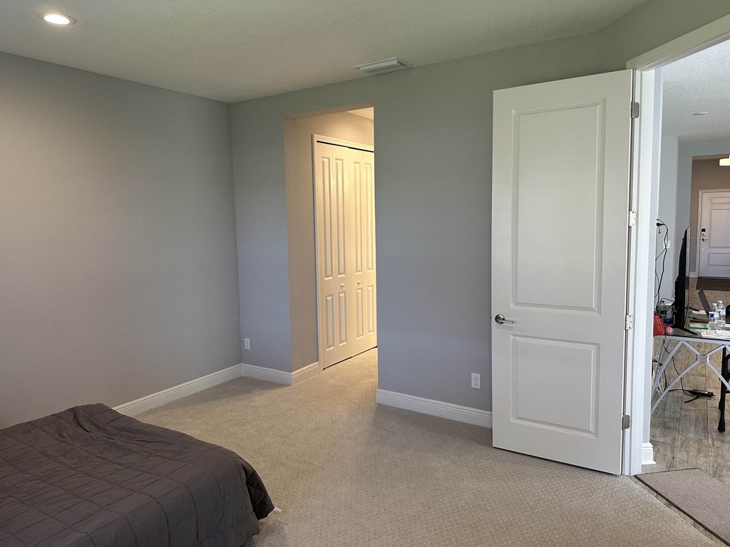 a bedroom with a white door and a closet