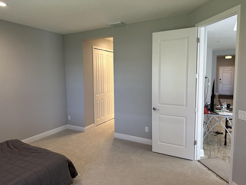 a bedroom with a white door and a closet