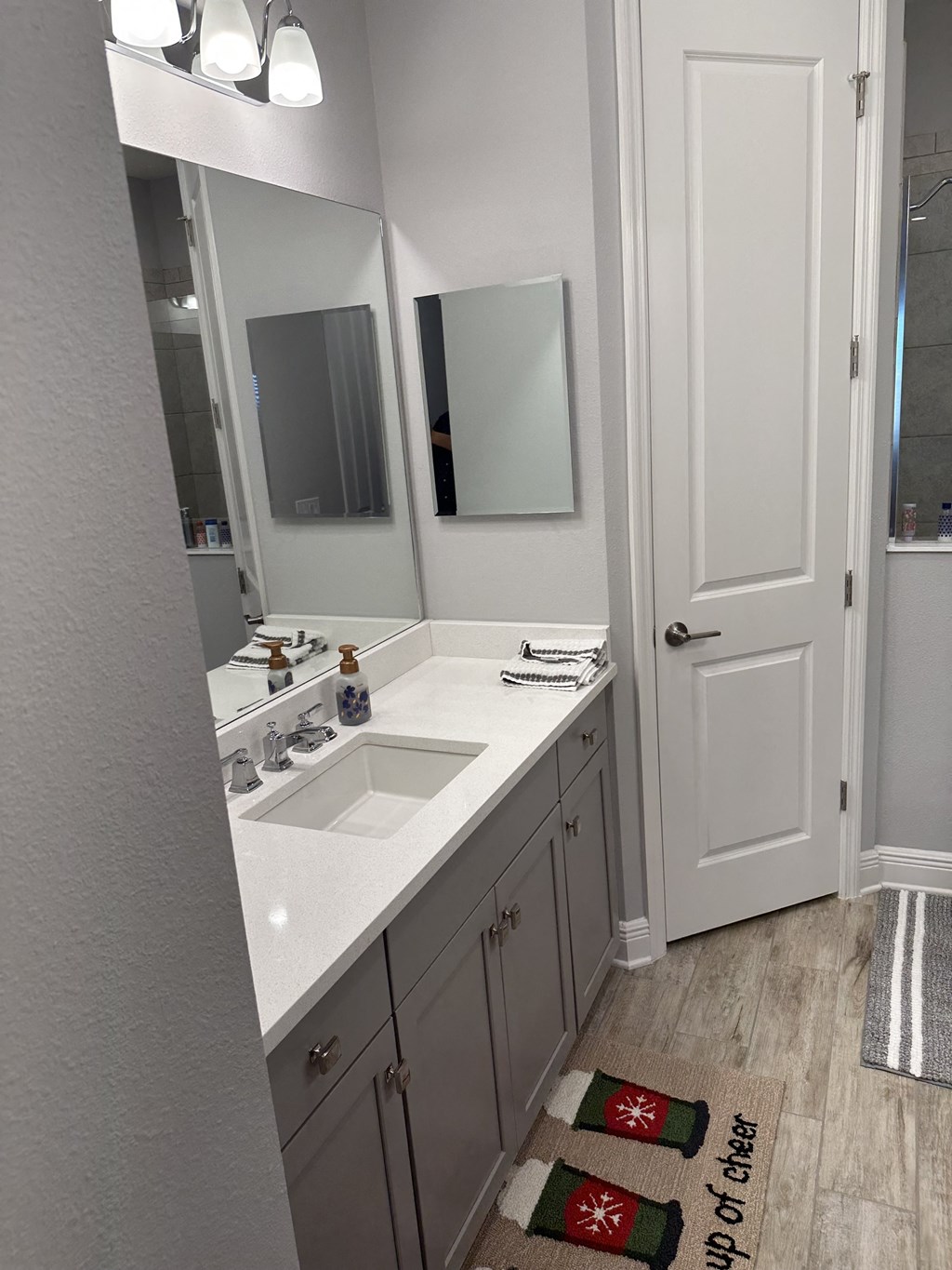 a bathroom with a sink and two mirrors in it