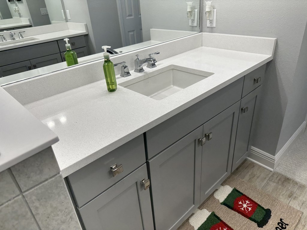 a bathroom with a white counter top and a sink