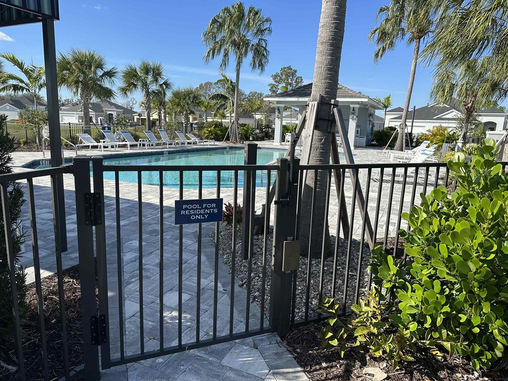 a pool gate at a resort with palm trees
