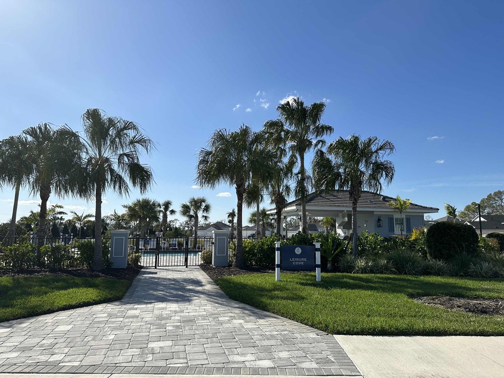 a house with palm trees in front of it and a driveway
