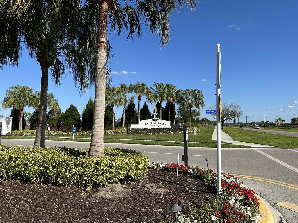 a street corner with palm trees and a sign for a church