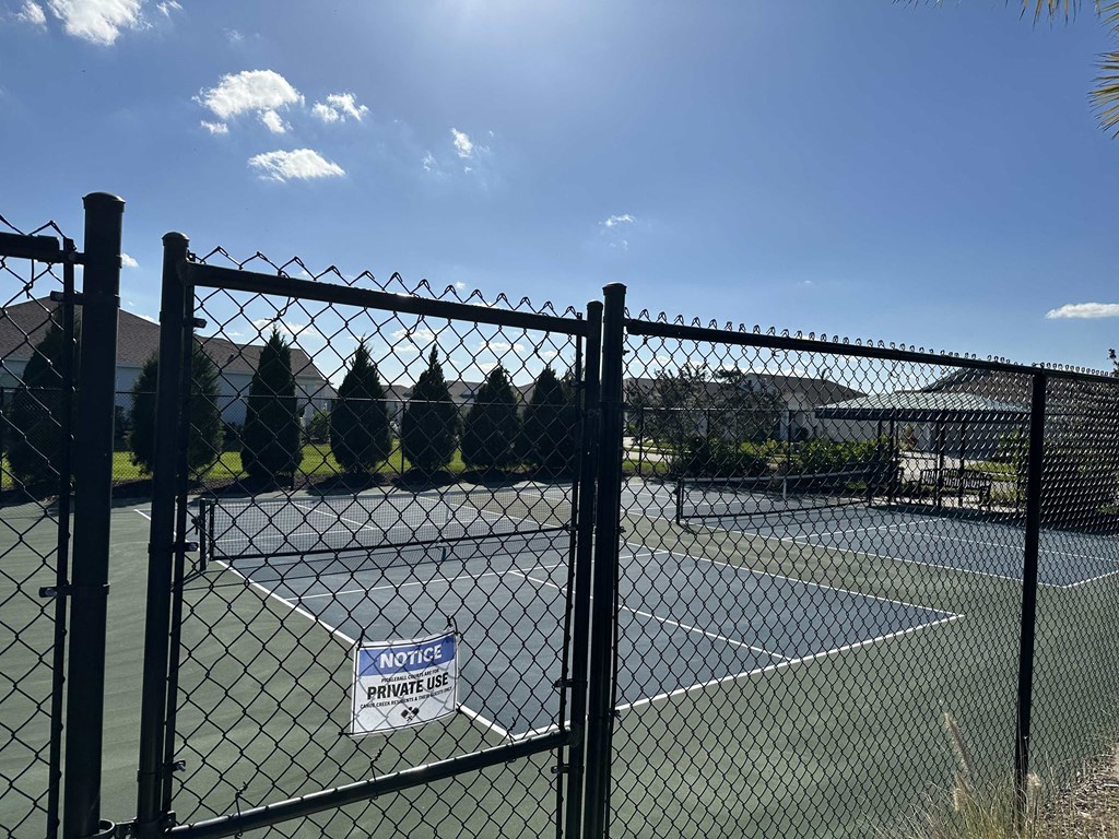 a tennis court is shown behind a fence