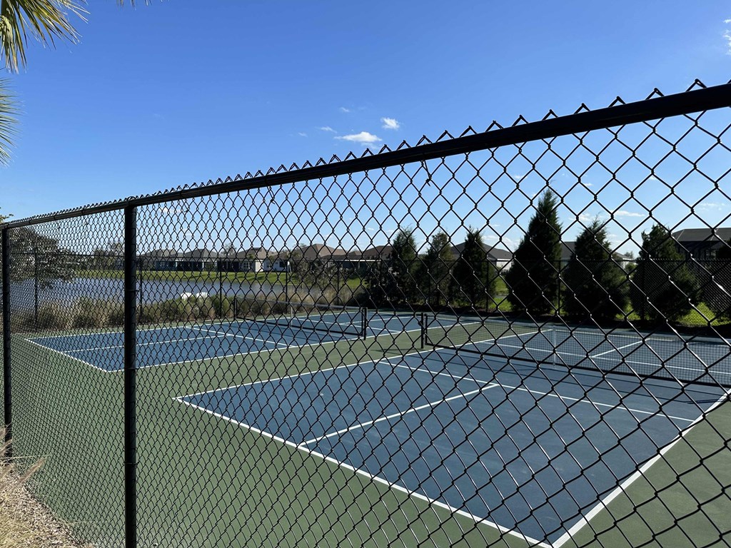a tennis court is shown behind a chain link fence