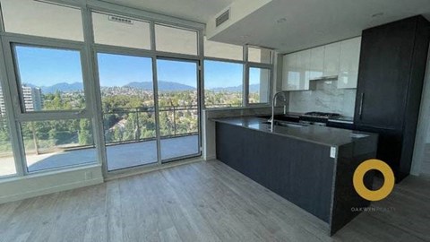 a kitchen with a large window and a black counter top