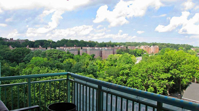 a balcony with a view of a city and trees