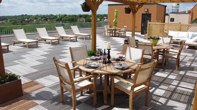 a patio with a dining table and chairs on a roof