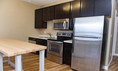 a kitchen with stainless steel appliances and a wooden table