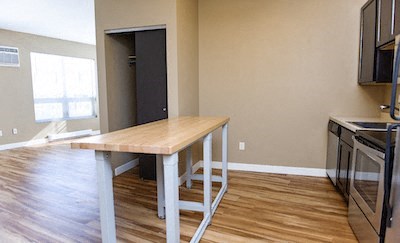 an empty kitchen with a wooden table in the middle