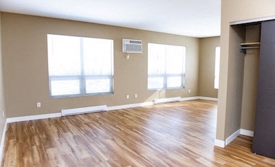 a living room with a hard wood floor and windows