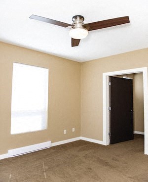 an empty room with a ceiling fan and a door