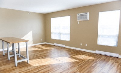 an empty living room with a wooden floor and a table