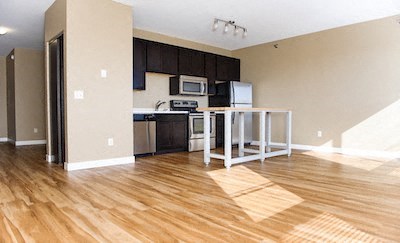 a kitchen and a living room with a wooden floor