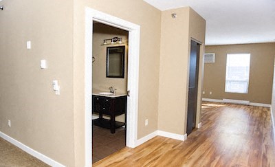 an empty room with a bathroom and a door way