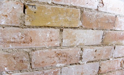 an old brick wall with a large yellow stain on it