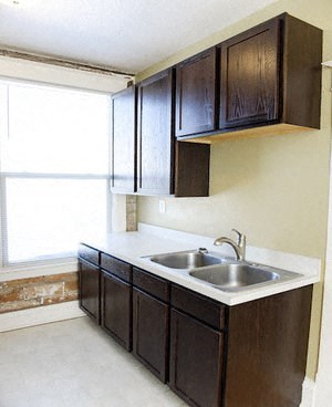 a kitchen with a sink and cabinets and a window