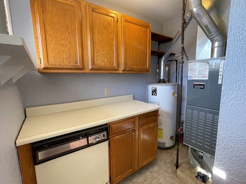 a kitchen with a stove and cabinets and a water heater