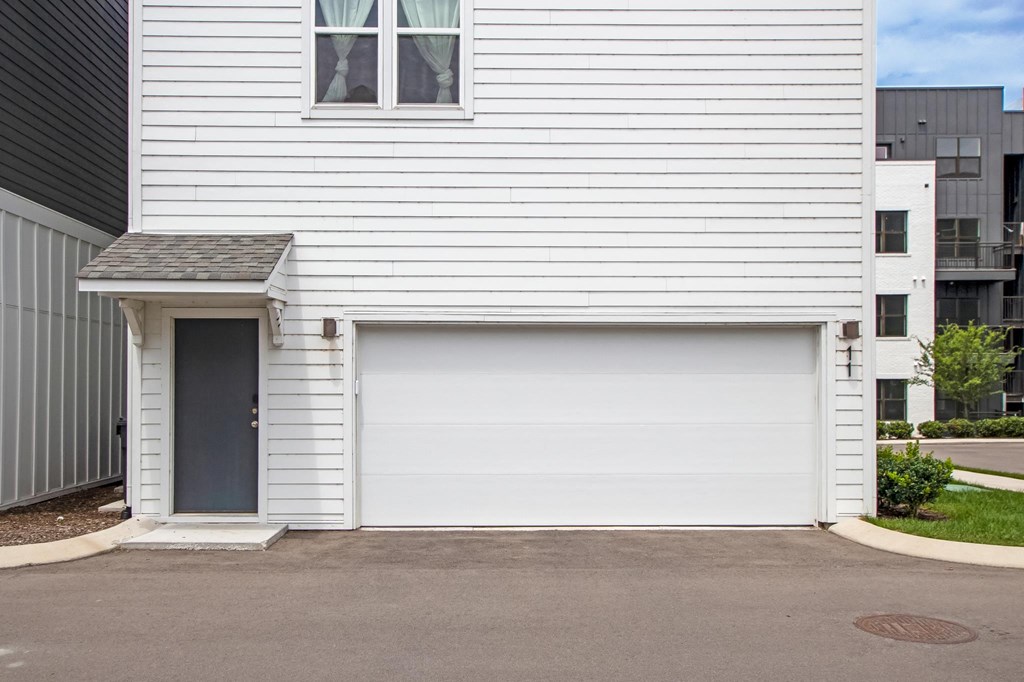 the front of a white house with a white garage door
