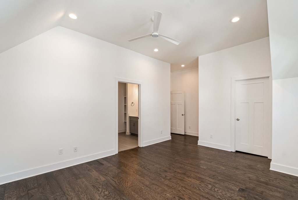 a living room with white walls and a ceiling fan