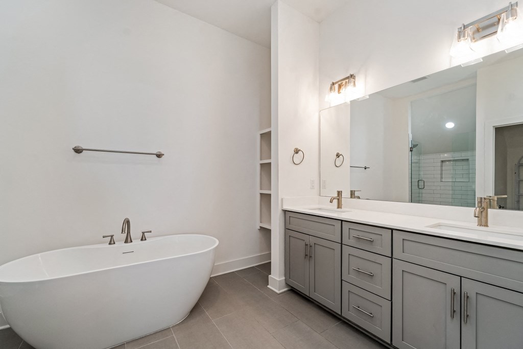 a bathroom with a tub and a sink and a mirror
