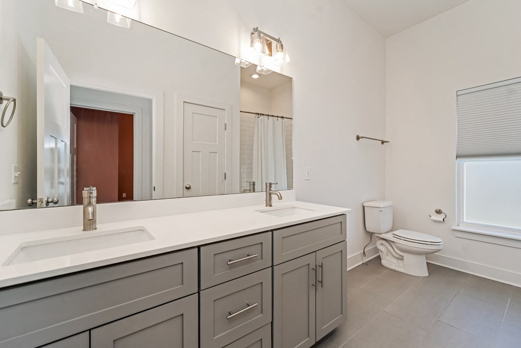 a bathroom with a large mirror and a sink and a toilet
