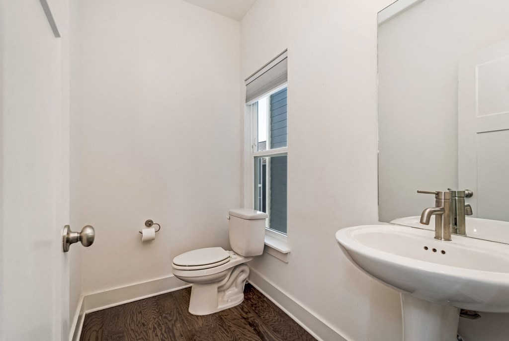 a bathroom with a toilet and a sink and a window