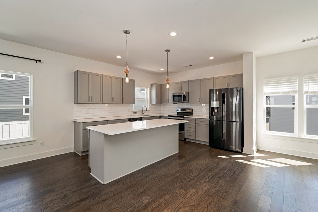 an open kitchen with a large island and stainless steel appliances