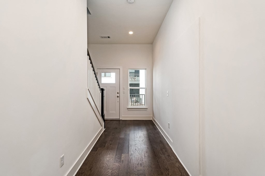 an empty living room with white walls and wood floors